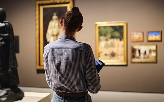 a woman looking at a painting