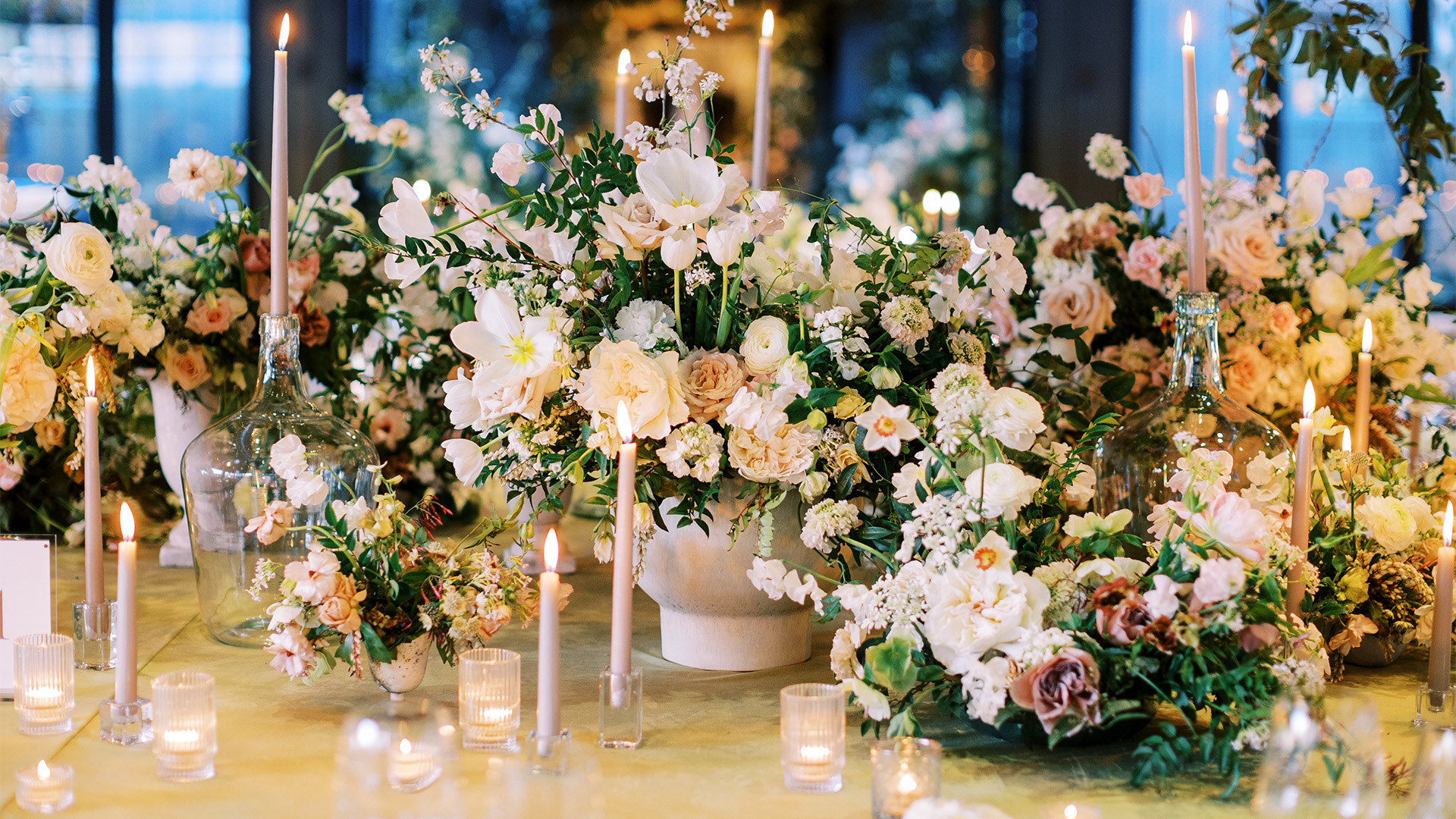 a group of flowers and candles on a table