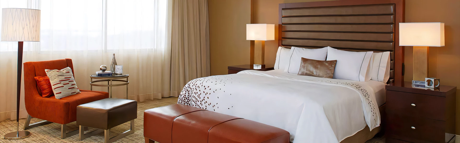 a bed with a lamp and a bench