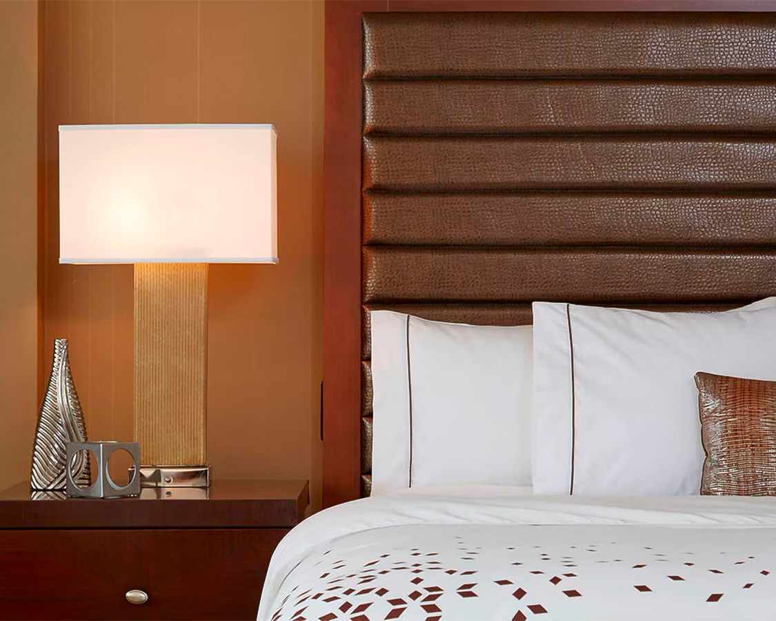 a bed with a lamp next to it