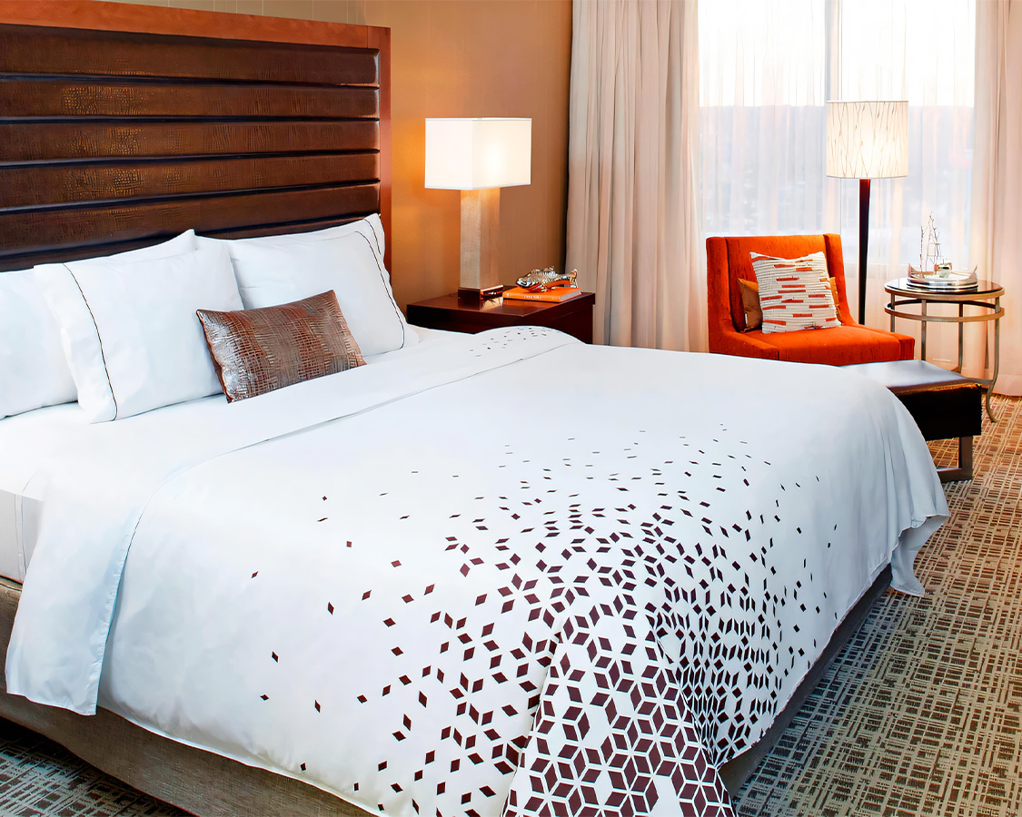 a bed with white sheets and pillows