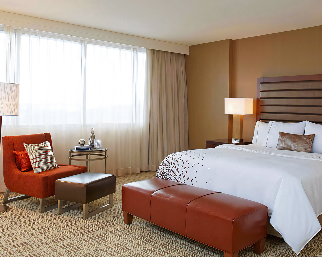 a bedroom with a bed and a chair