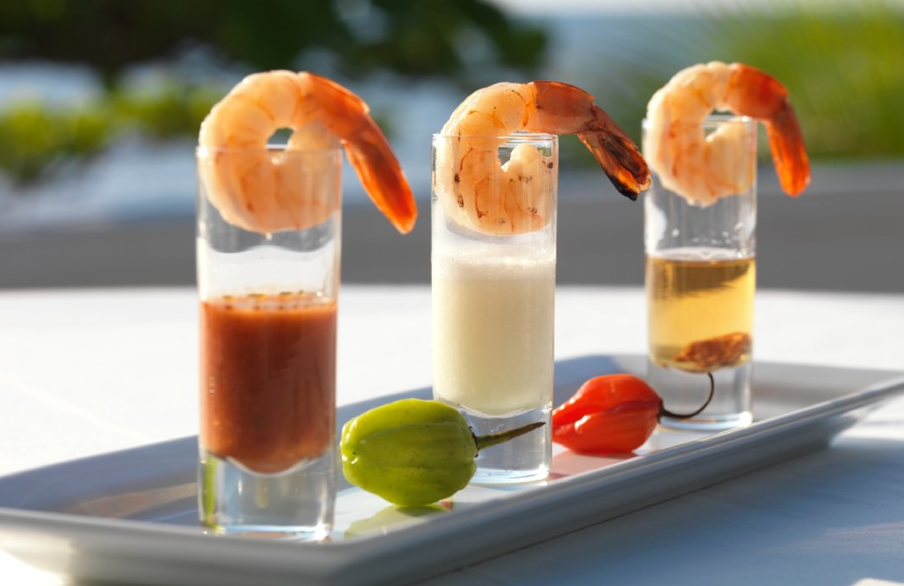 a group of shrimp shots with sauces on a plate
