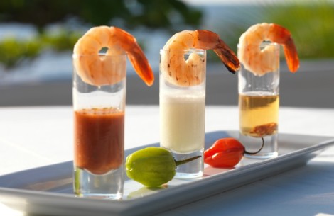 a group of shrimp shots with sauces on a plate