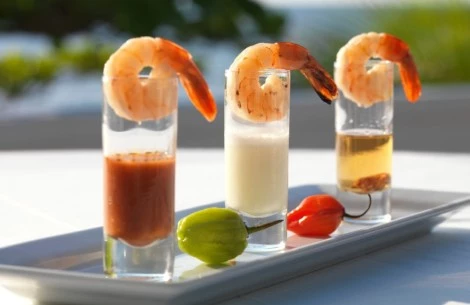 a group of shrimp shots with sauces on a plate