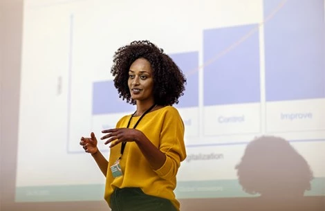 a woman standing in front of a large screen