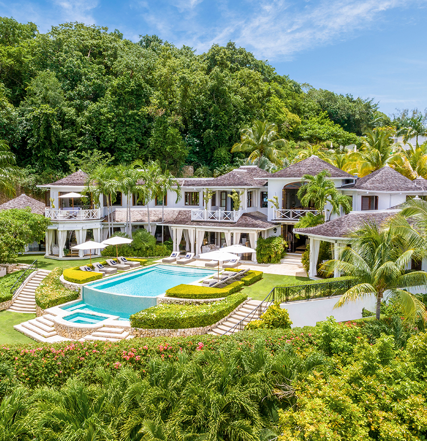 a large house with a pool surrounded by trees