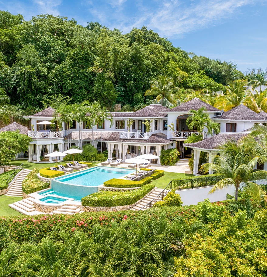 a large house with a pool surrounded by trees