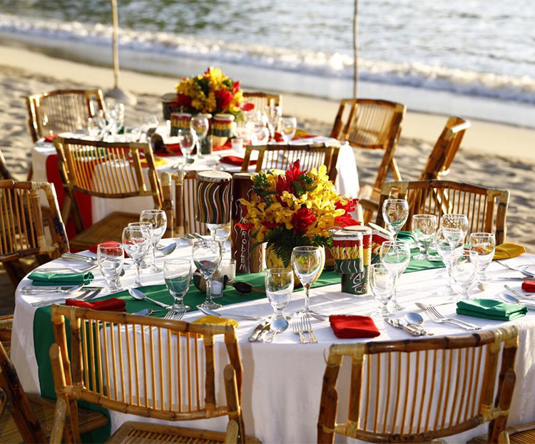 a table set for a dinner party on a beach