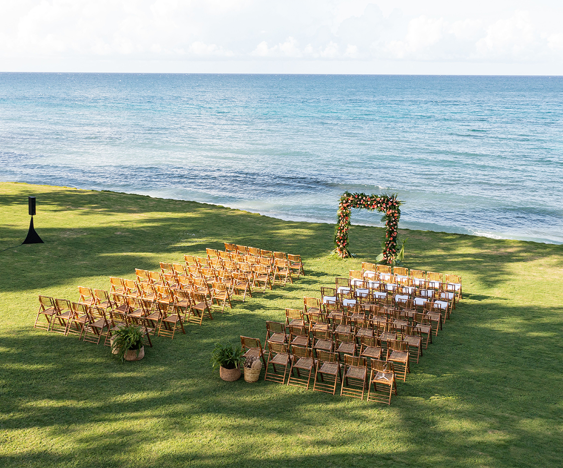 a group of chairs on a lawn with a large body of water