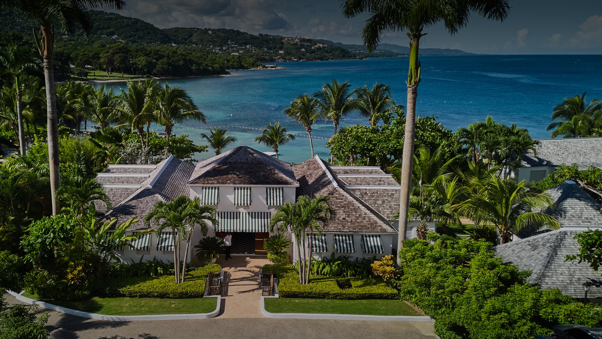 a house with palm trees and a body of water