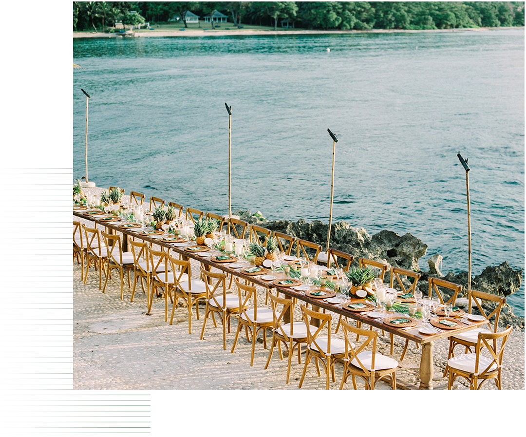 a long table set with chairs and flowers on it