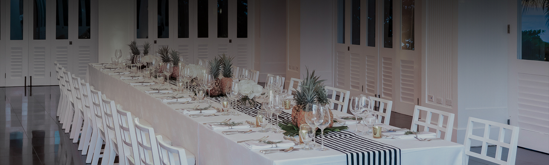 a table with white and black striped tablecloths and glasses
