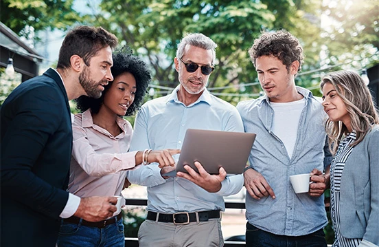 a group of people looking at a laptop