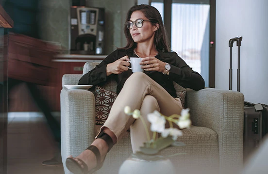 a woman sitting in a chair holding a cup