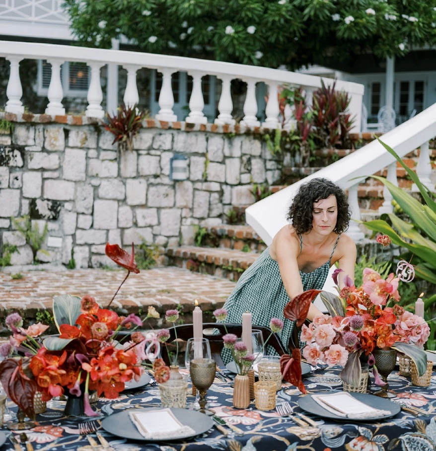 a woman in a dress at a table with flowers