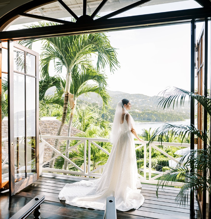 a woman in a wedding dress standing on a balcony