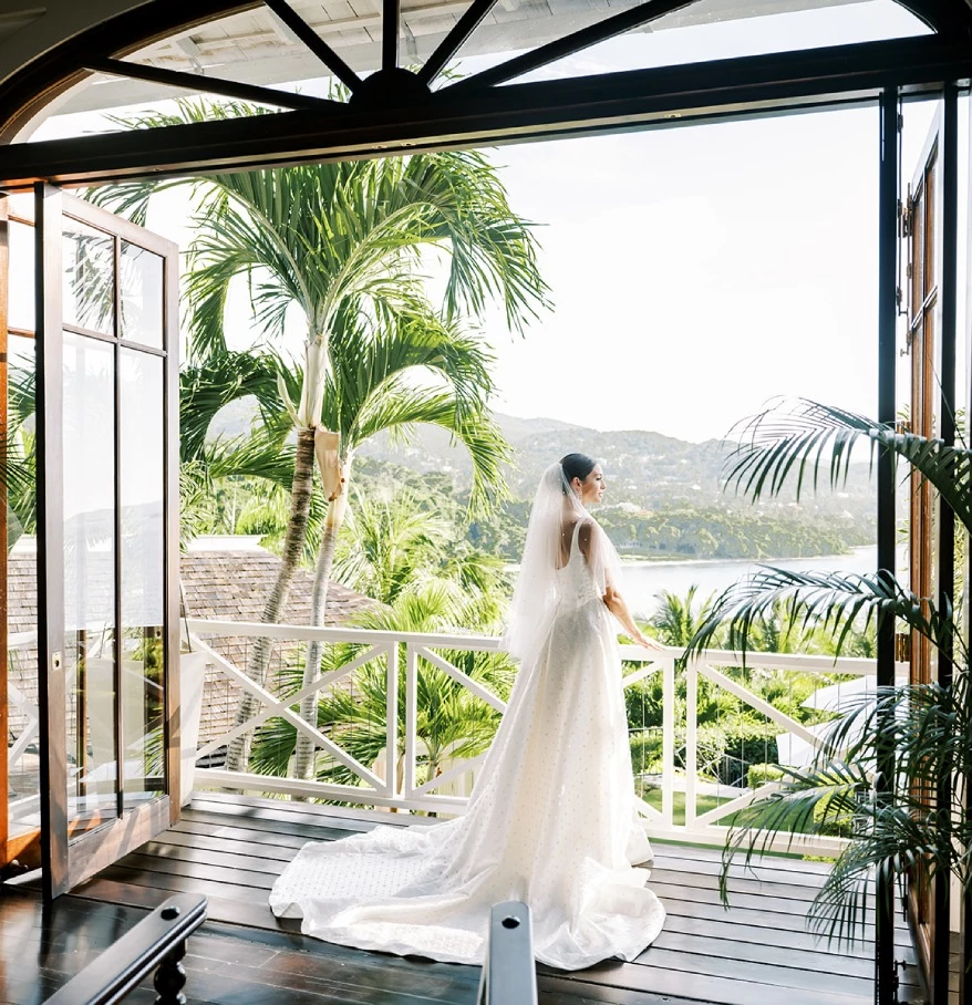 a woman in a wedding dress standing on a balcony