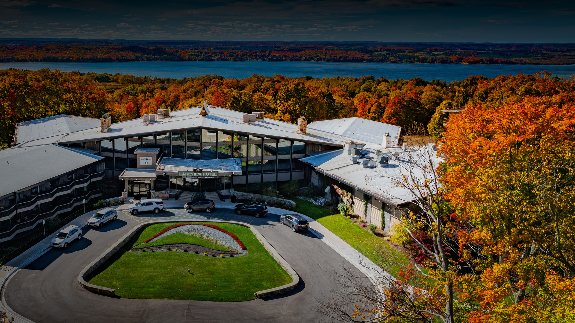 a building with cars parked in front of a lake