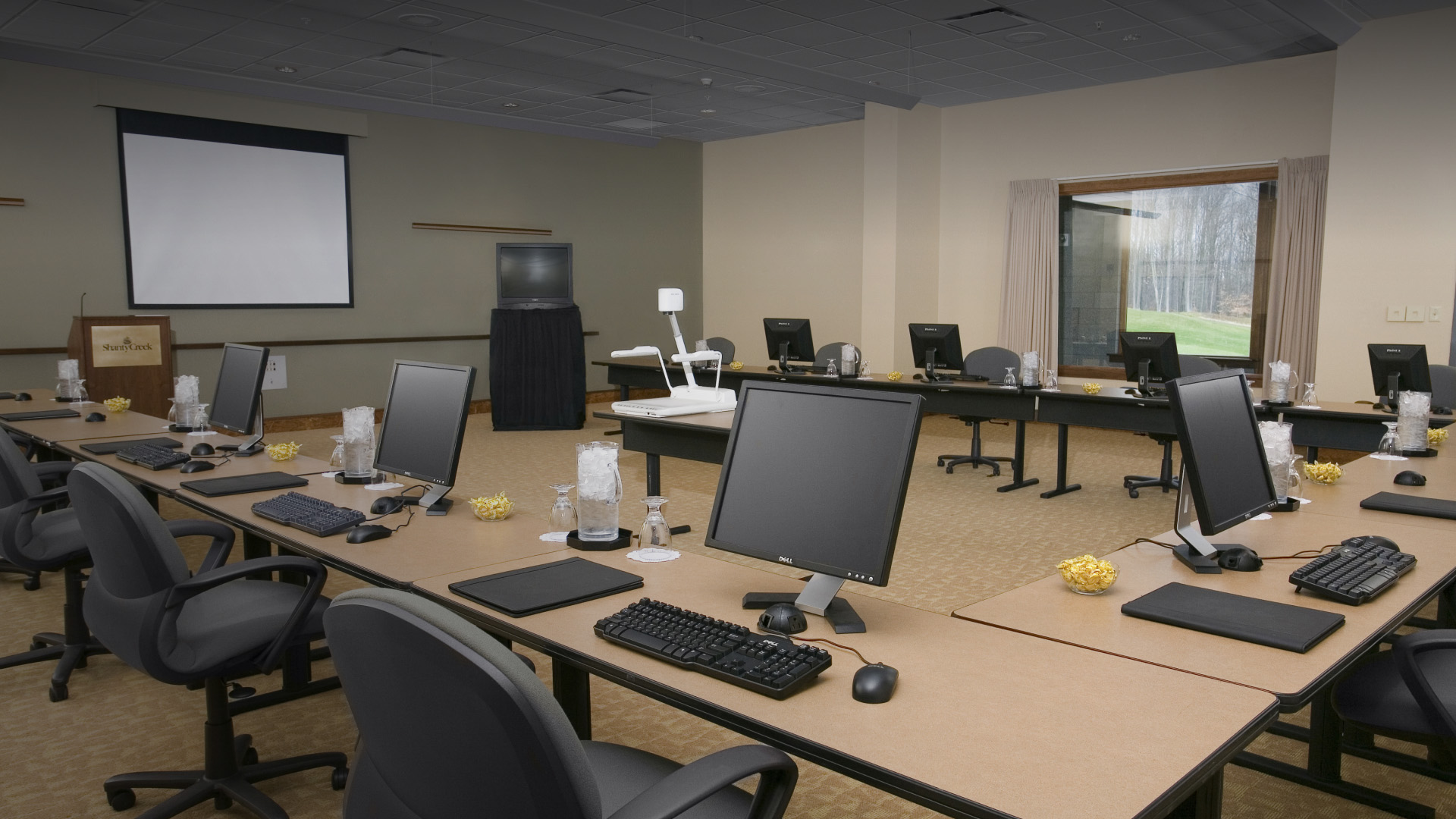 a room with computers and a projector screen