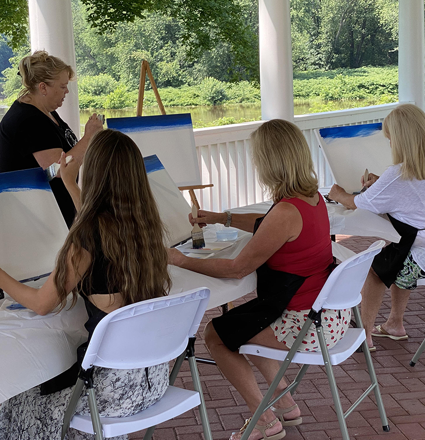 a group of women painting on canvases