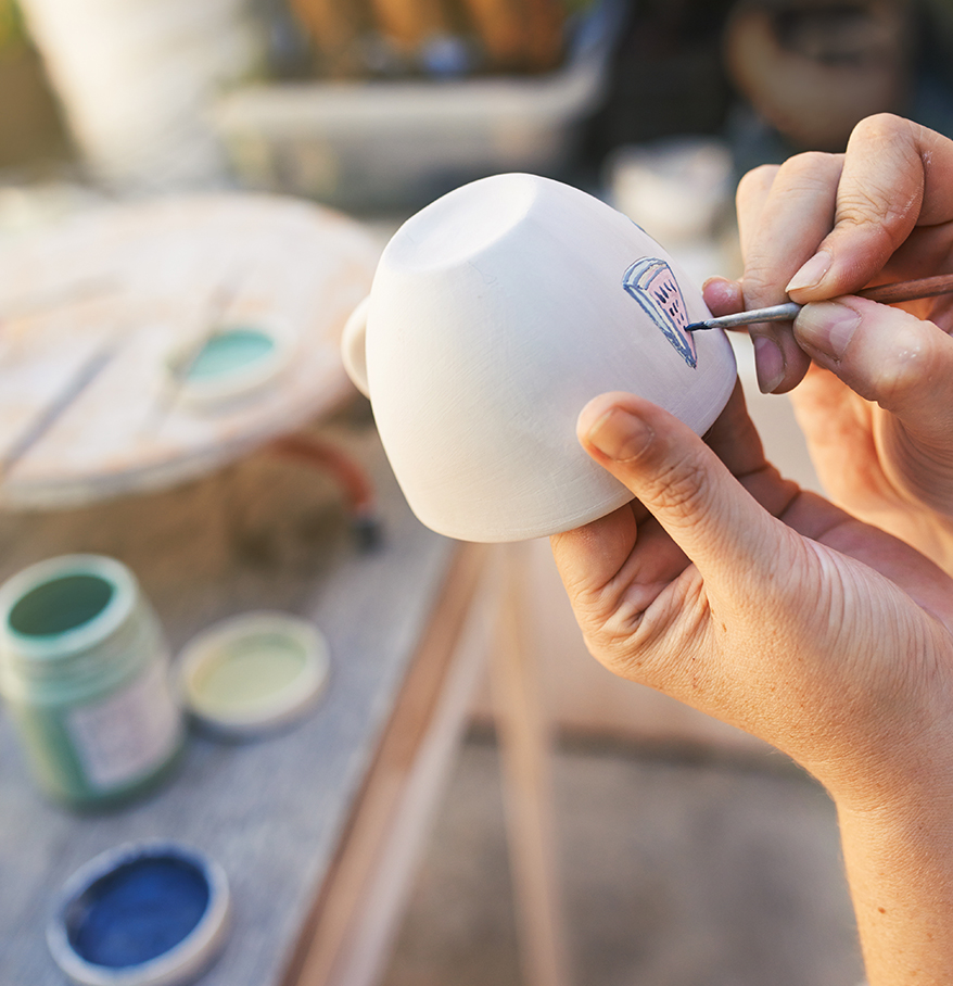 a person painting a cup