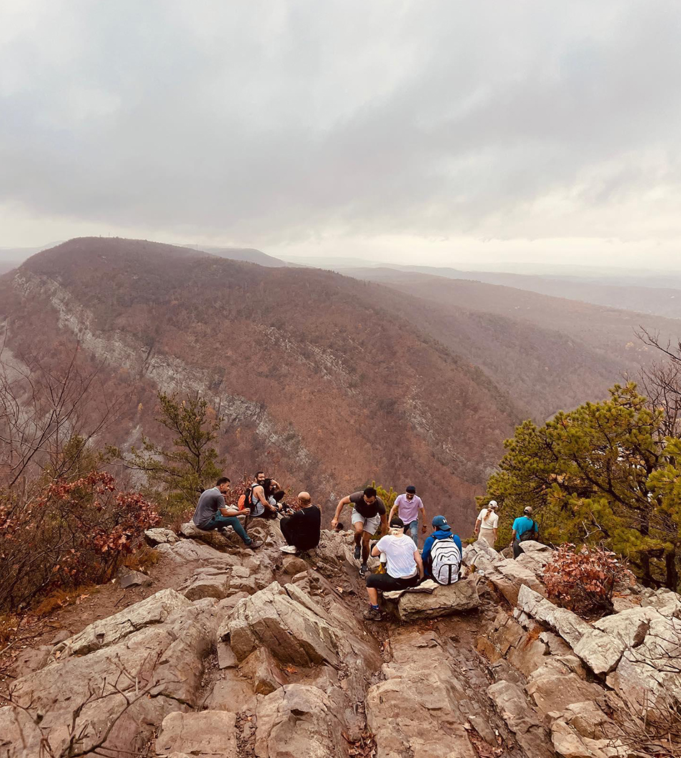 a group of people sitting on a rocky hill
