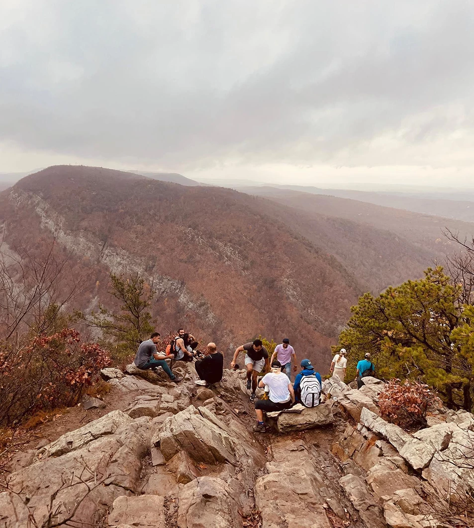 a group of people sitting on a rocky hill
