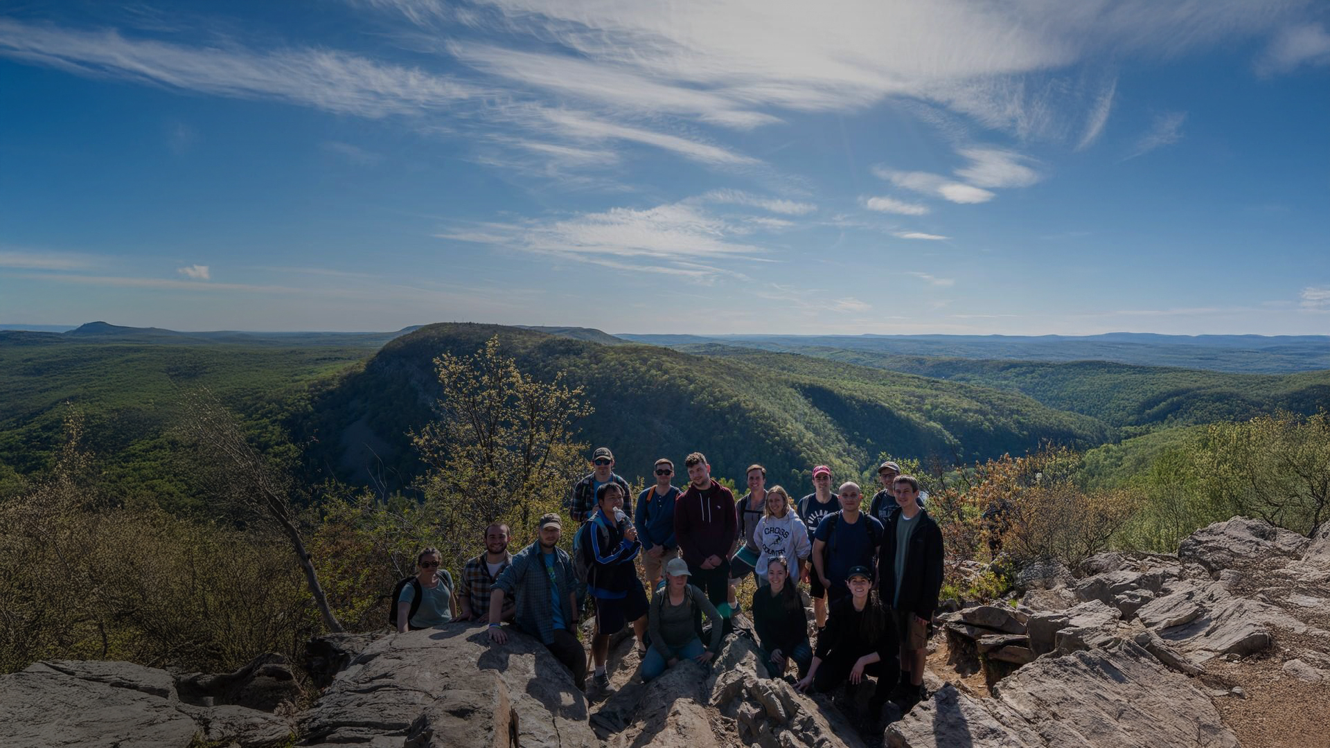 a group of people posing for a photo on a rocky cliff