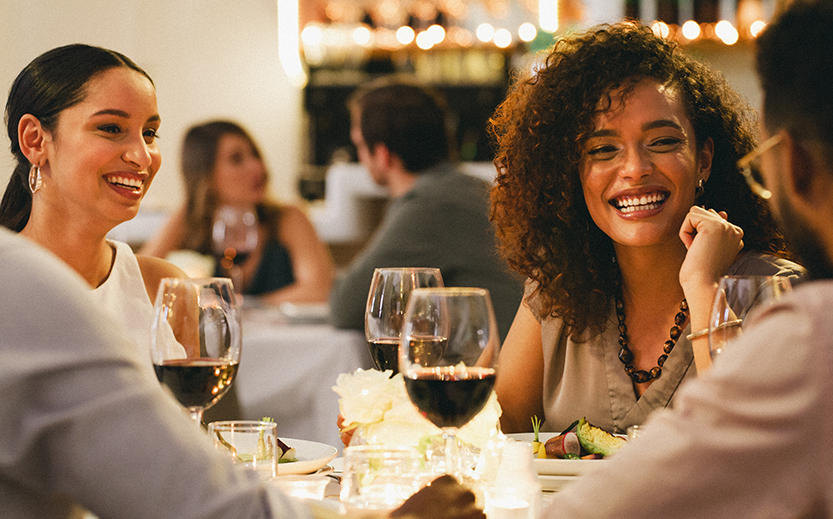 a group of people sitting at a table with wine glasses