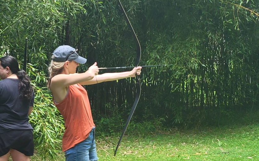 a woman shooting a bow and arrow