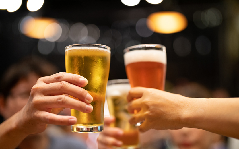 a group of hands holding glasses of beer