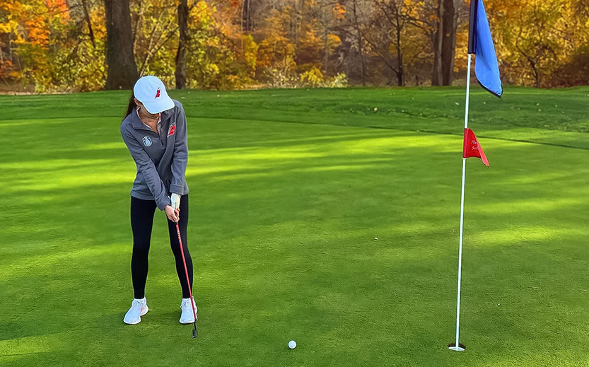 a woman playing golf on a golf course