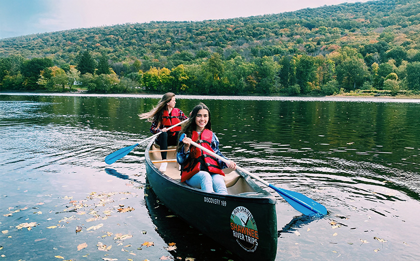 two girls in a canoe on a lake
