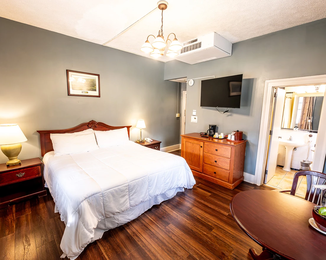 a room with a bed and a table and a television