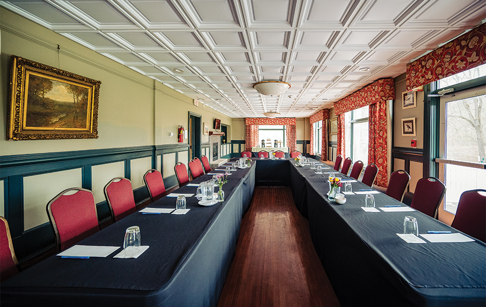 a long table with black tablecloths and red chairs