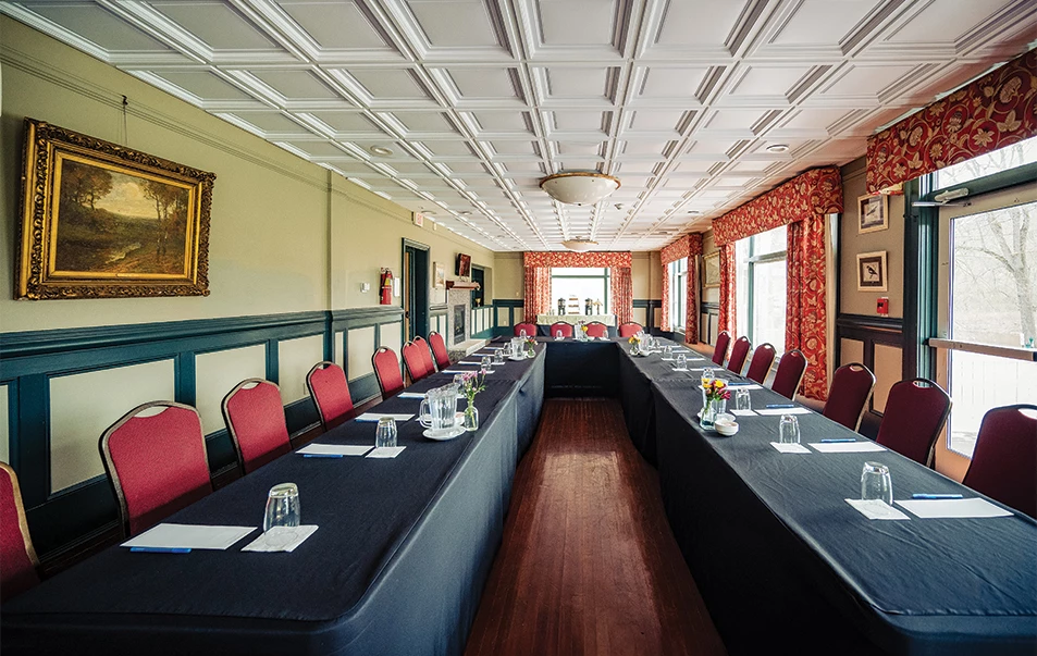 a long table with black tablecloths and red chairs