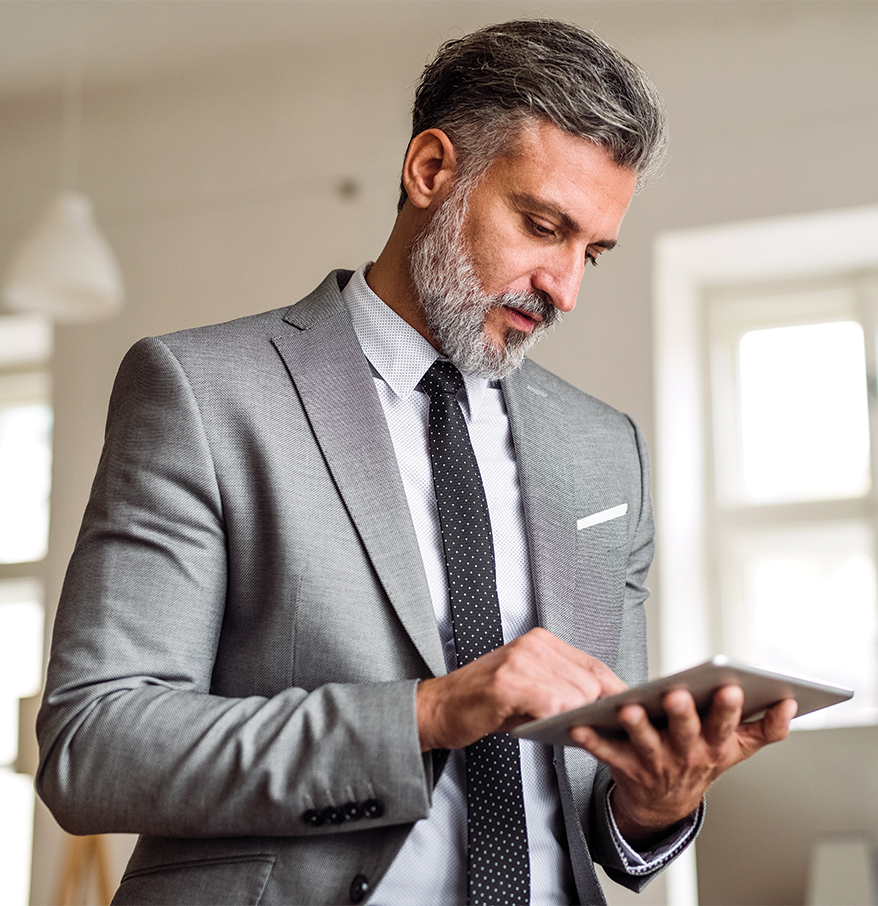 a man in a suit and tie using a tablet