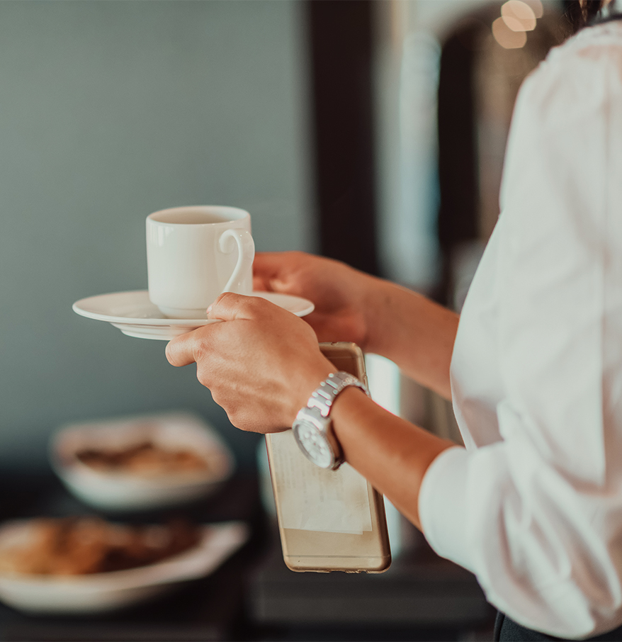 a person holding a cup and saucer