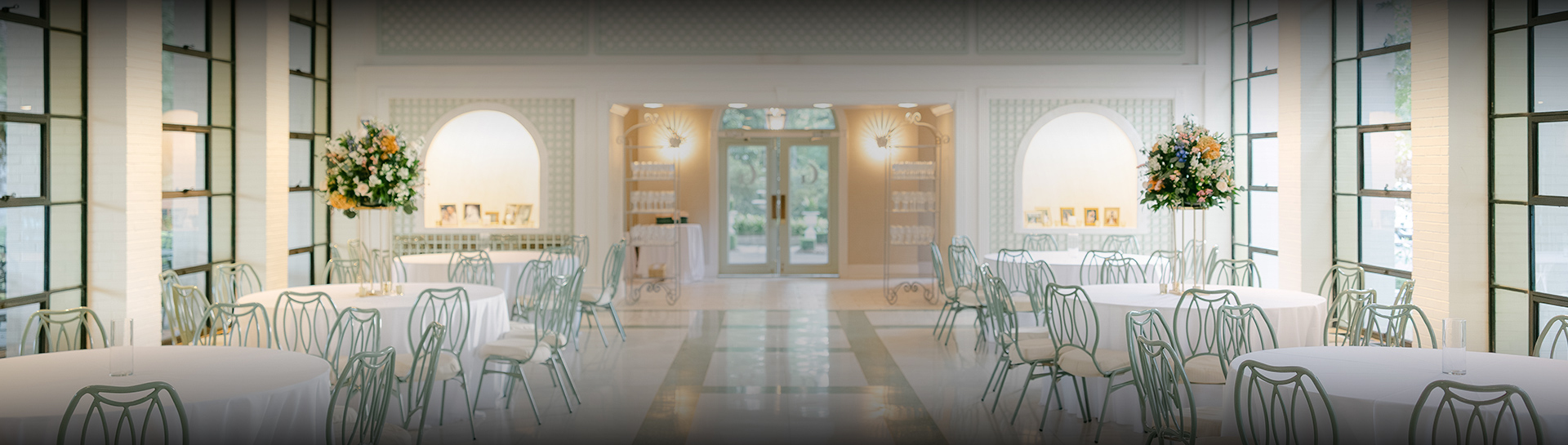 a room with white chairs and tables