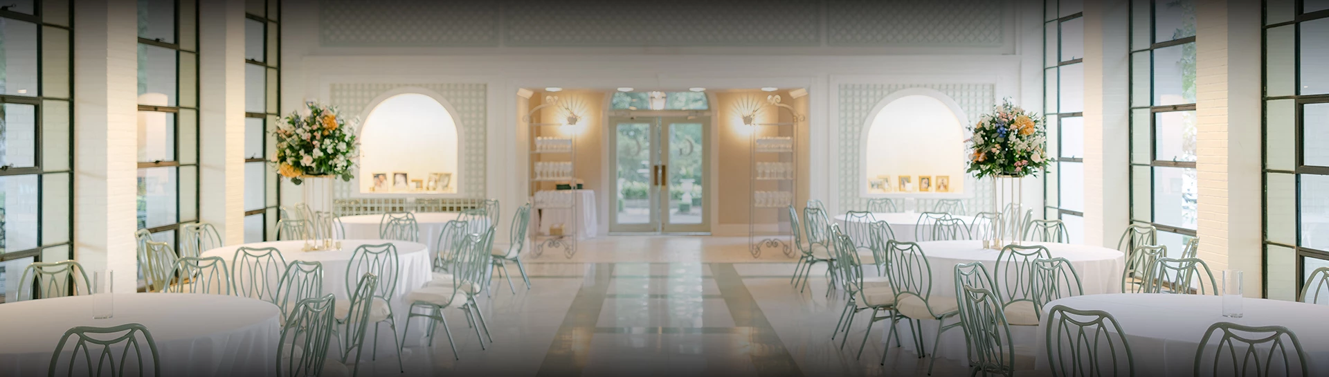 a room with white chairs and tables