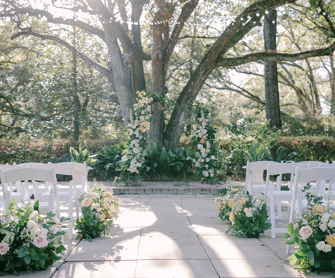 a wedding ceremony with white chairs and flowers