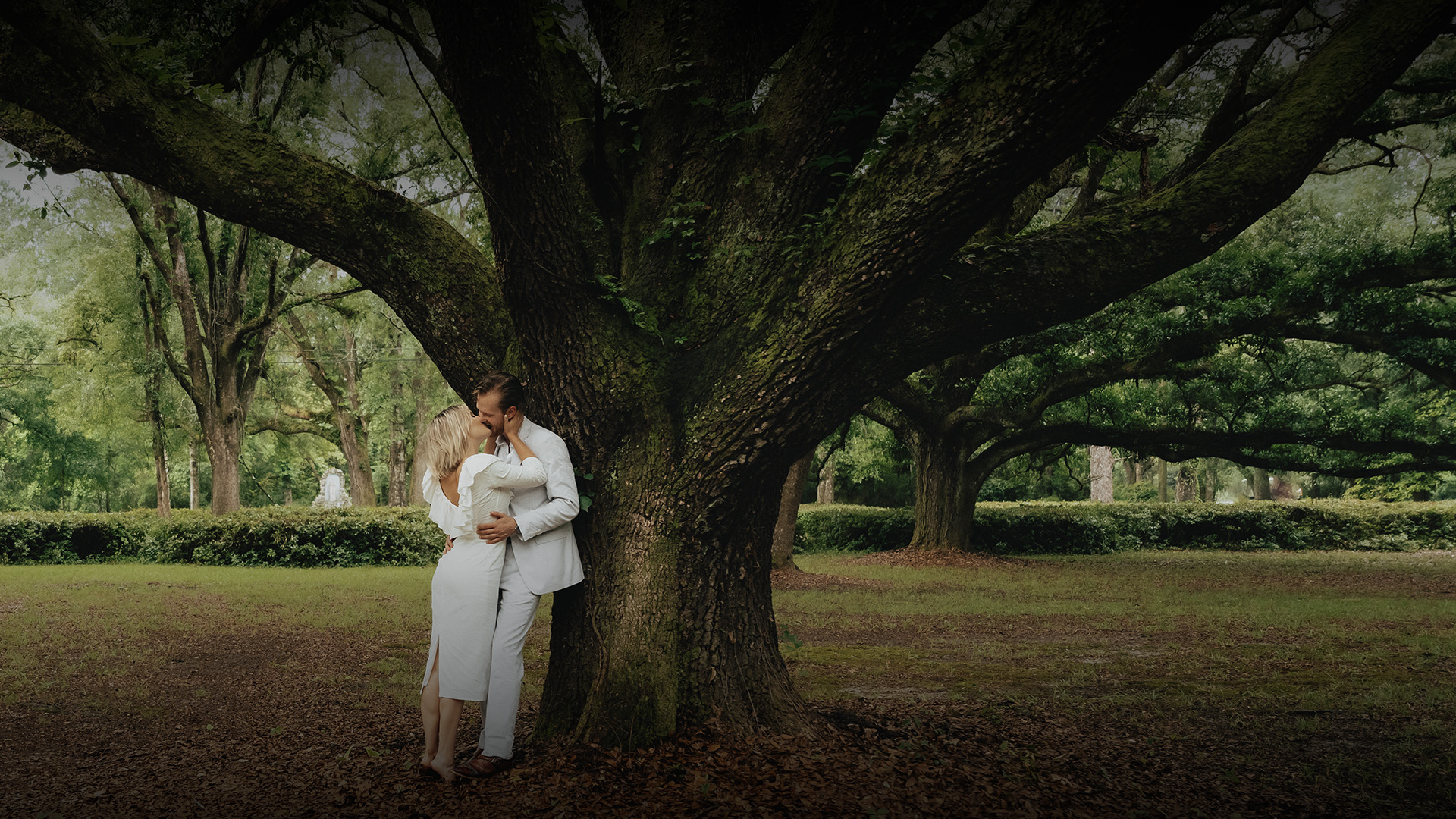 a man and woman kissing in a park