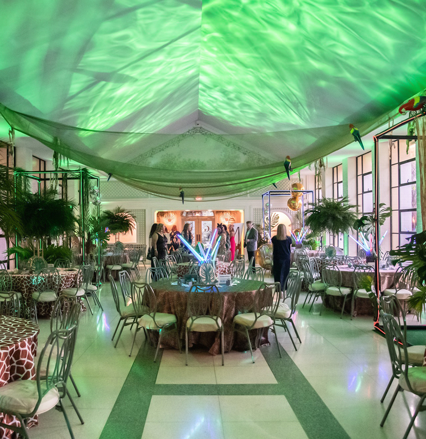 a room with tables and chairs and green lights