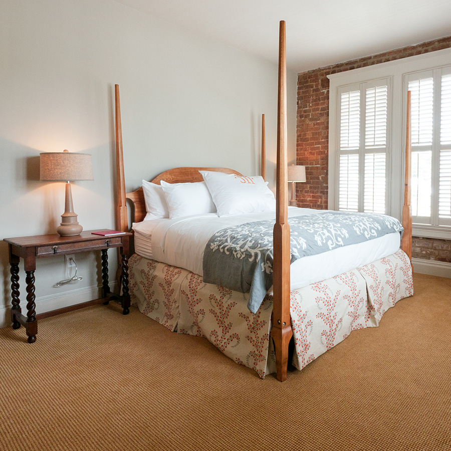 a bed with four posts and a lamp in a room