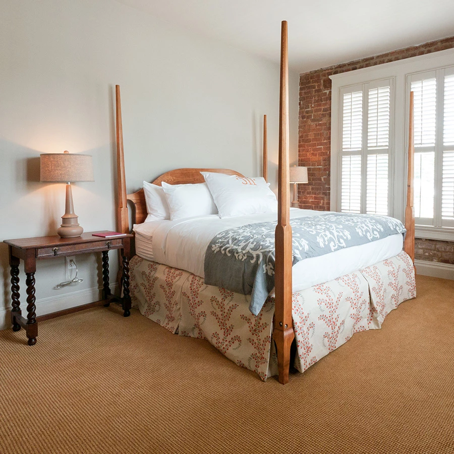 a bed with four posts and a lamp in a room