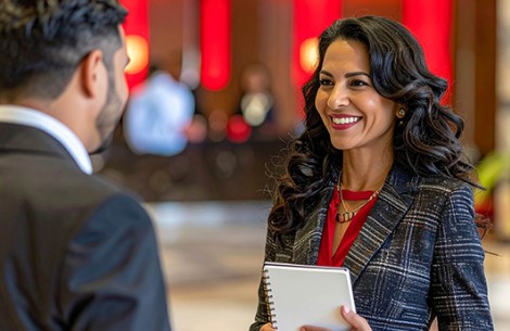 a woman holding a notebook and smiling to a man