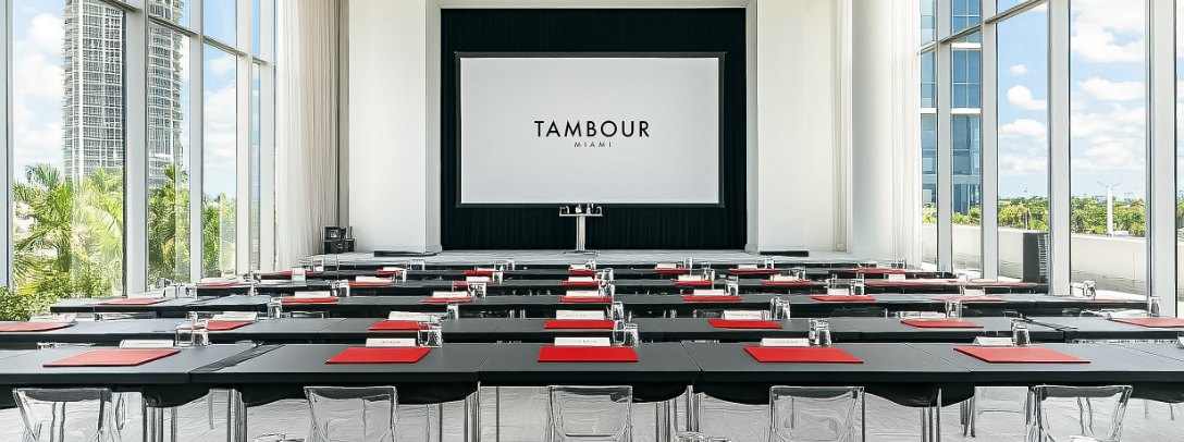 a room with tables and chairs and a projector screen
