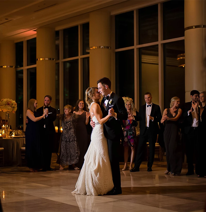 a man and woman dancing in a room with people in the background