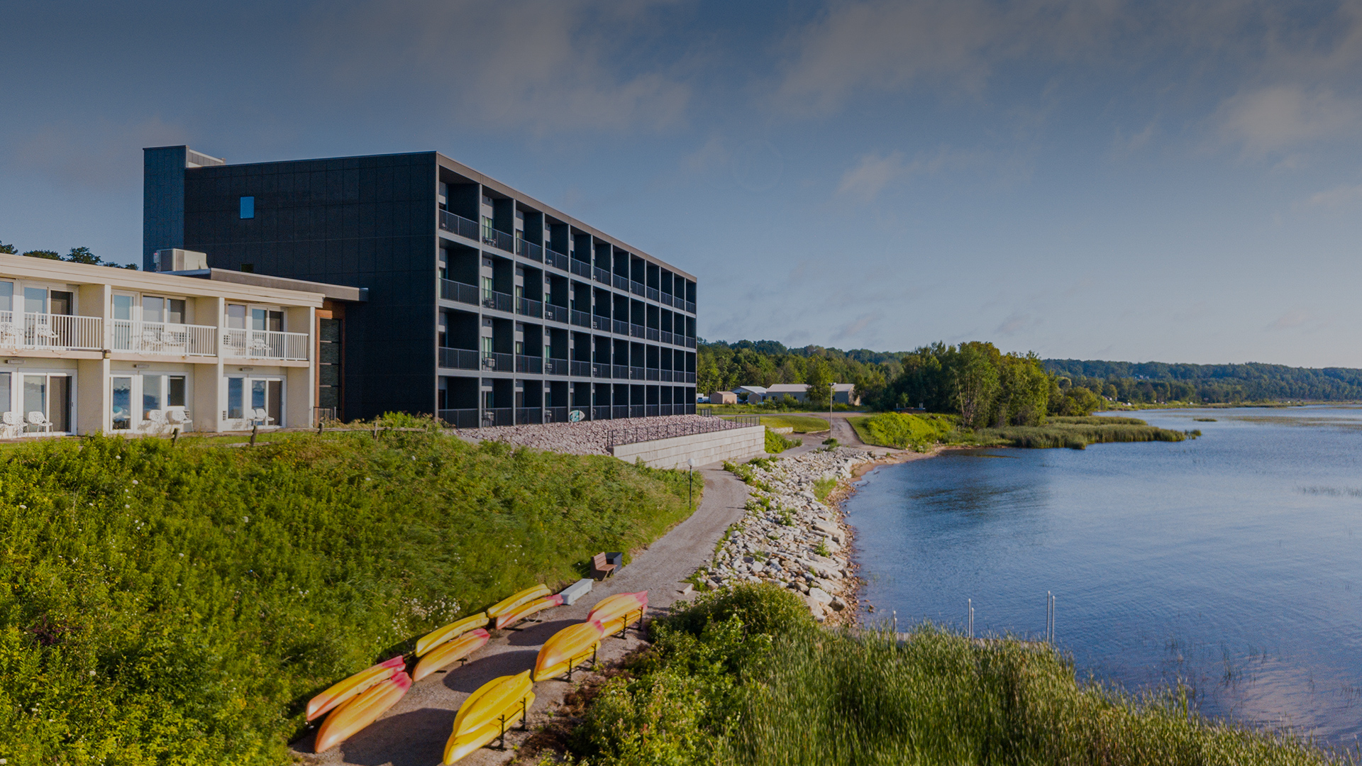 a building with a lake and kayaks